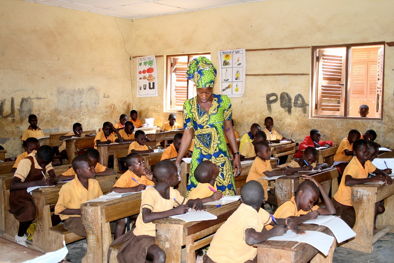 Teacher attending to a class full of children.